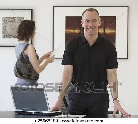 Stock Photo - Businessman leaning on desk. Fotosearch