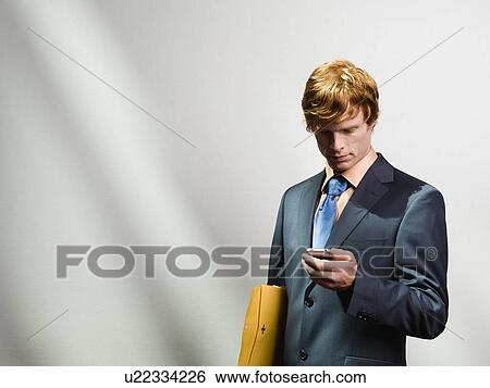 Businessman looking at cell phone View Large Photo Image Stock Photograph - Businessman looking at cell phone. Fotosearch