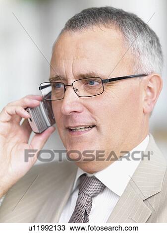 Stock Image - Businessman talking on cell phone. Fotosearch