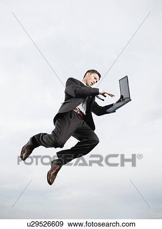 Stock Photo - Businessman with laptop n mid-air. Fotosearch
