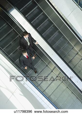 Stock Photograph - Businessmen descending escalator. Fotosearch