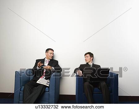 Businessmen sitting in chairs in office lobby View Large Photo Image Stock Image - Businessmen sitting in chairs in office lobby. Fotosearch