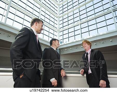 Picture - Businessmen socializing in convention center atrium. Fotosearch