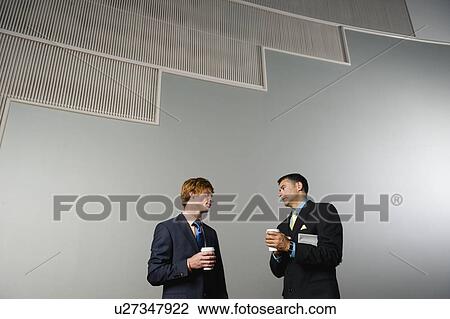 Stock Image - Businessmen talking during coffee break. Fotosearch