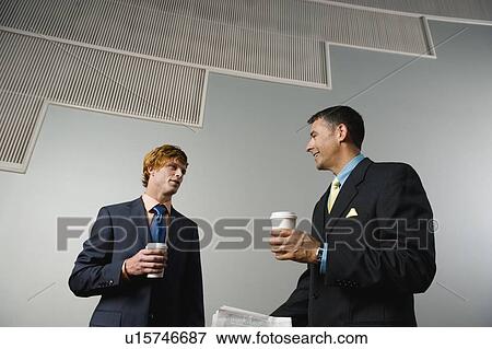 Stock Photo - Businessmen talking during coffee break. Fotosearch