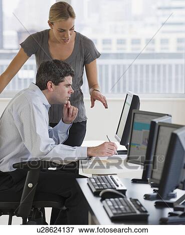 Stock Photo - Businesspeople looking at computer. Fotosearch