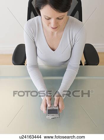 Picture - Businesswoman looking at electronic organizer. Fotosearch