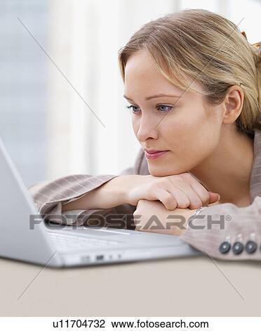 Businesswoman looking at laptop View Large Photo Image Stock Image - Businesswoman looking at laptop. Fotosearch