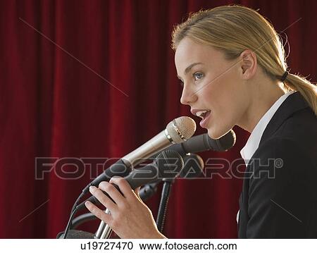 Businesswoman speaking into microphone View Large Photo Image Stock Image - Businesswoman speaking into microphone. Fotosearch