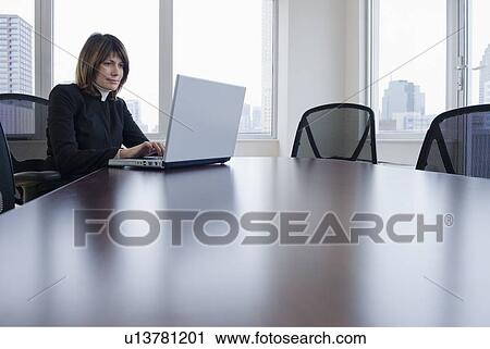 Businesswoman using laptop in conference room View Large Photo Image Stock Image - Businesswoman using laptop in conference room. Fotosearch