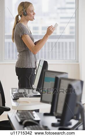 Stock Image - Businesswoman wearing headset. Fotosearch