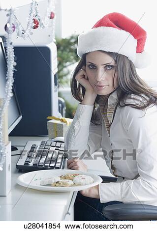 Picture - Businesswoman wearing Santa Claus hat. Fotosearch