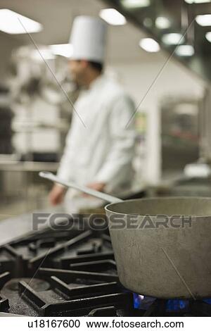 Stock Image - Chef and pot on stove. Fotosearch