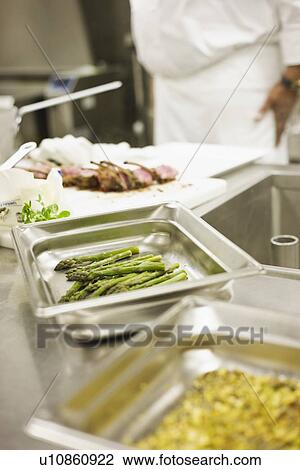 Chef preparing food in commercial kitchen View Large Photo Image Stock Image - Chef preparing food in commercial kitchen. Fotosearch