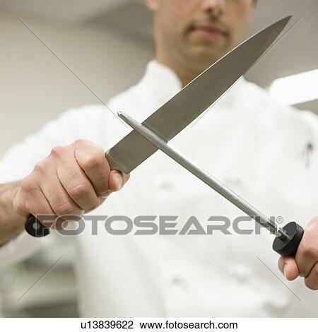 Chef sharpening knife in kitchen View Large Photo Image Stock Image - Chef sharpening knife in kitchen. Fotosearch