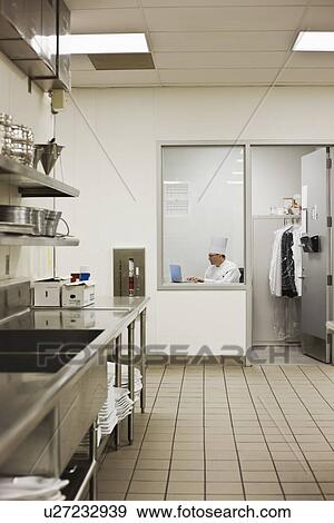 Stock Photo - Chef sitting in kitchen office. Fotosearch