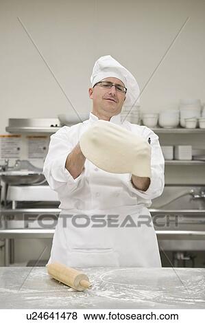 Stock Photo - Chef stretching pizza dough. Fotosearch