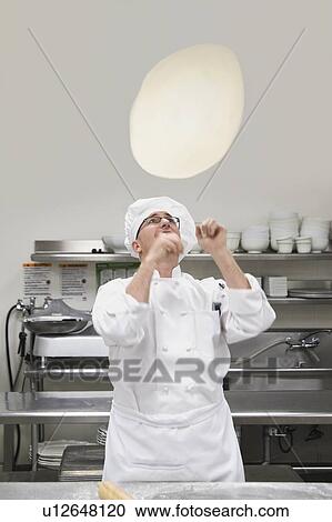 Stock Image - Chef tossing pizza dough. Fotosearch