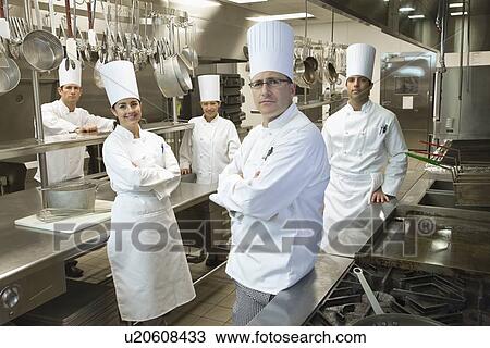 Stock Image - Chefs posing in kitchen. Fotosearch