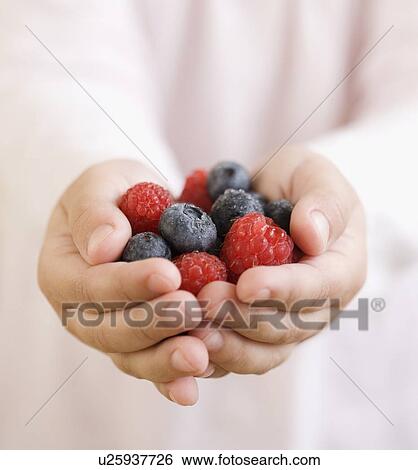 Stock Photograph - Child holding handful of berries. Fotosearch