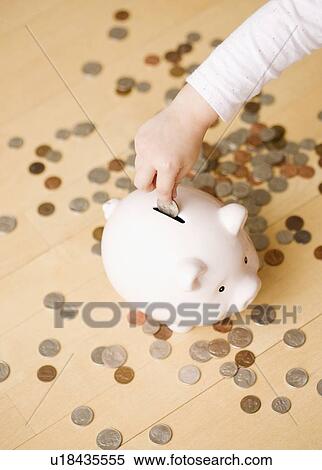 Child putting coin in piggy bank View Large Photo Image Stock Photography - Child putting coin in piggy bank. Fotosearch