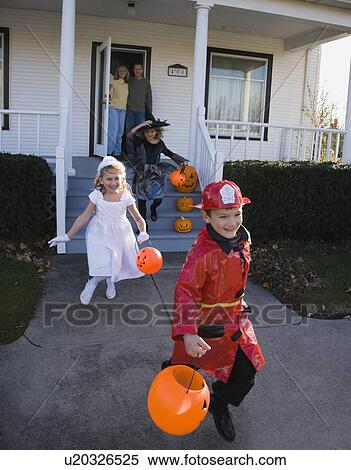 Stock Photography - Children dressed in Halloween costumes leaving house. Fotosearch