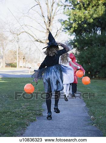 Children in Halloween costumes skipping on sidewalk View Large Photo Image Stock Image - Children in Halloween costumes skipping on sidewalk. Fotosearch