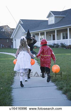 Children in Halloween costumes skipping on sidewalk View Large Photo Image Stock Photograph - Children in Halloween costumes skipping on sidewalk. Fotosearch