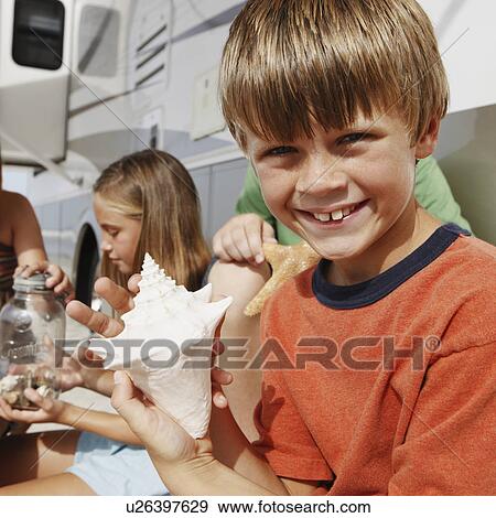 Children looking at seashell collection by motor home View Large Photo Image Stock Photo - Children looking at seashell collection by motor home. Fotosearch