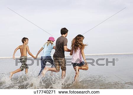 Stock Image - Children running in ocean. Fotosearch