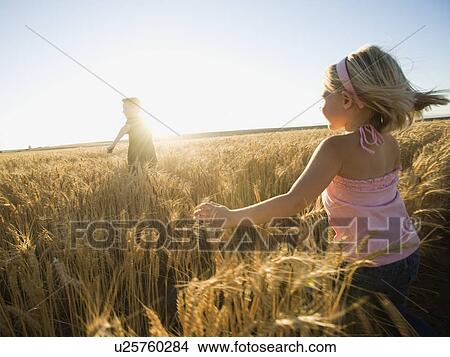 Picture - Children running through tall wheat field. Fotosearch
