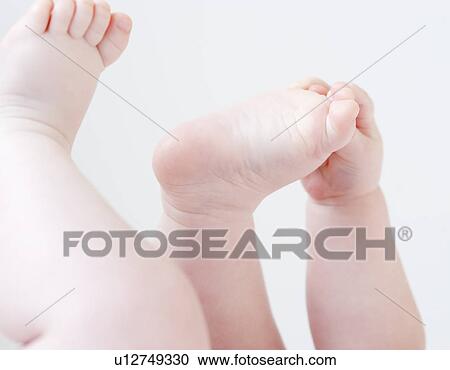 Close up of baby grabbing feet View Large Photo Image Stock Image - Close up of baby grabbing feet. Fotosearch