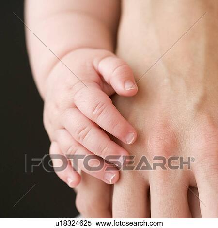 Close up of baby touching mother’s hand View Large Photo Image Stock Photography - Close up of baby touching mother’s hand. Fotosearch