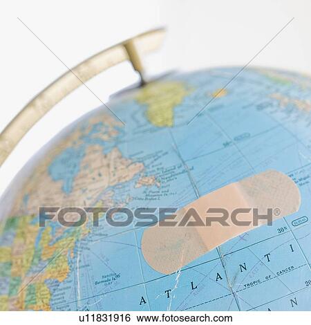 Stock Photograph - Close up of bandage on globe. Fotosearch