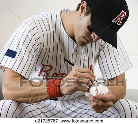 Stock Photo - Close up of baseball player autographing baseball. Fotosearch