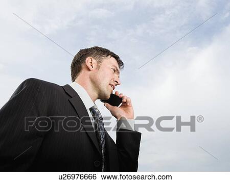 Stock Photograph - Close up of businessman talking on cell phone. Fotosearch