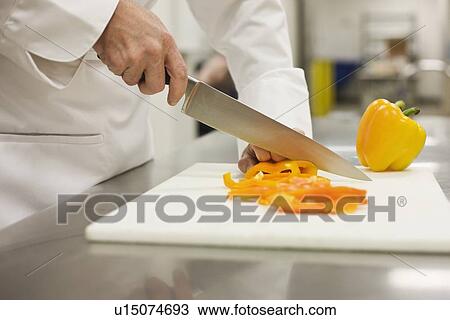 Stock Image - Close up of chef chopping bell pepper. Fotosearch