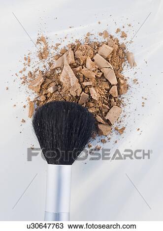 Stock Image - Close up of crushed cosmetic and brush. Fotosearch