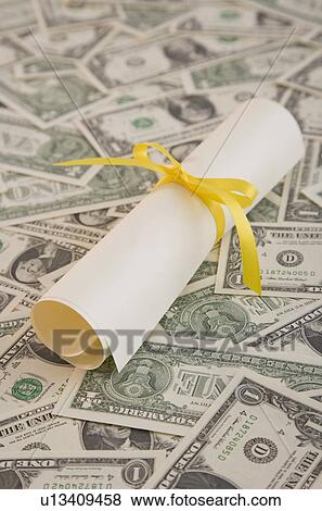 Close up of diploma on money View Large Photo Image Stock Photo - Close up of diploma on money. Fotosearch
