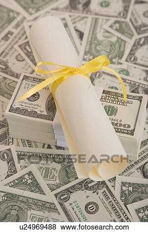 Close up of diploma on money View Large Photo Image Stock Photo - Close up of diploma on money. Fotosearch