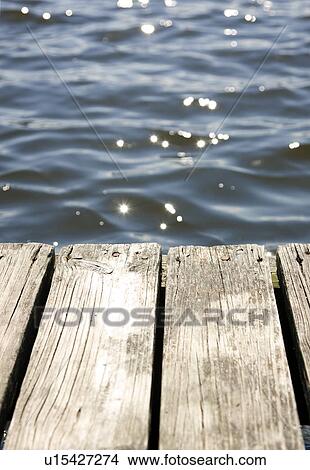 Close up of dock and sun reflecting on lake View Large Photo Image Picture - Close up of dock and sun reflecting on lake. Fotosearch