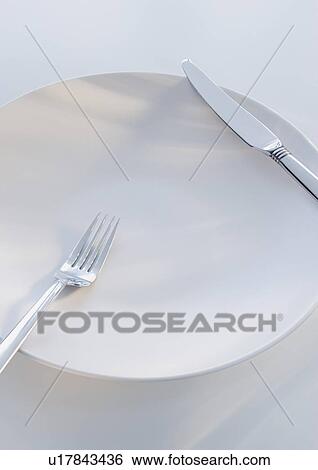 Stock Photograph - Close up of fork and knife on plate. Fotosearch