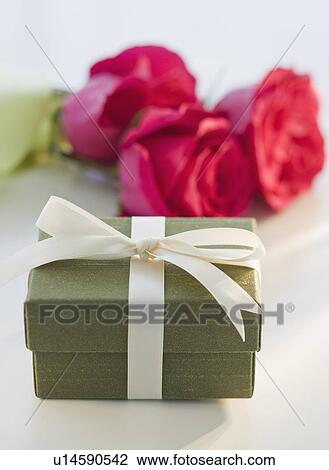 Stock Image - Close up of gift box and flowers. Fotosearch