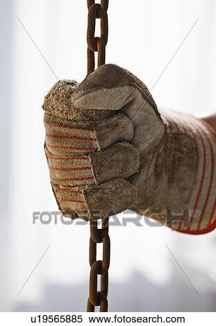 Stock Photography - Close up of gloved hand holding chain. Fotosearch