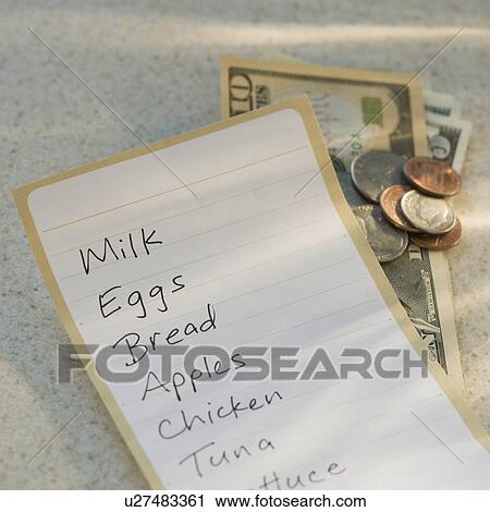 Stock Image - Close up of grocery list and money. Fotosearch
