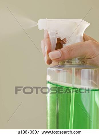 Stock Photo - Close up of hand and spray bottle. Fotosearch