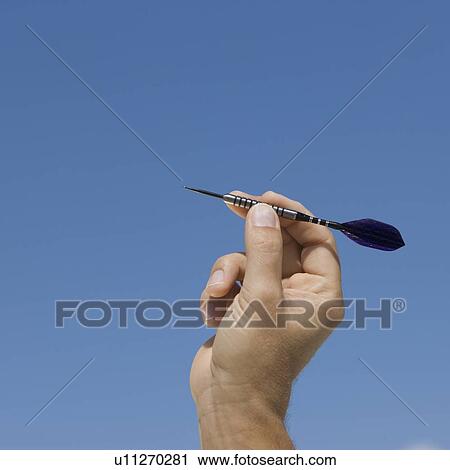 Close up of hand holding dart View Large Photo Image Stock Image - Close up of hand holding dart. Fotosearch