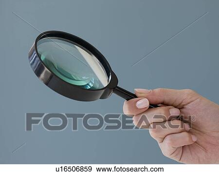 Close up of hand holding magnifying glass View Large Photo Image Stock Photo - Close up of hand holding magnifying glass. Fotosearch