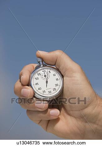 Stock Photography - Close up of hand holding stopwatch. Fotosearch