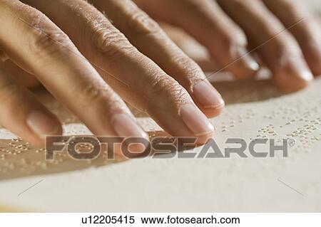 Stock Photography - Close up of hand reading braille. Fotosearch